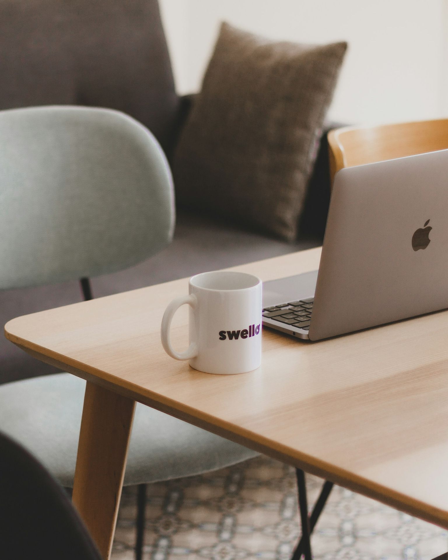 a coffee mug sitting on a table next to a laptop